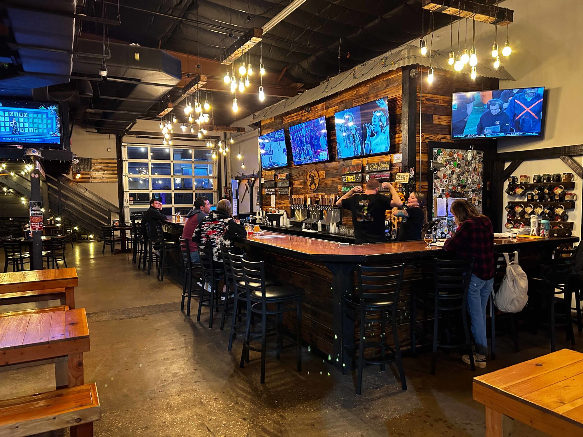 bar with stools and tvs with rustic decor